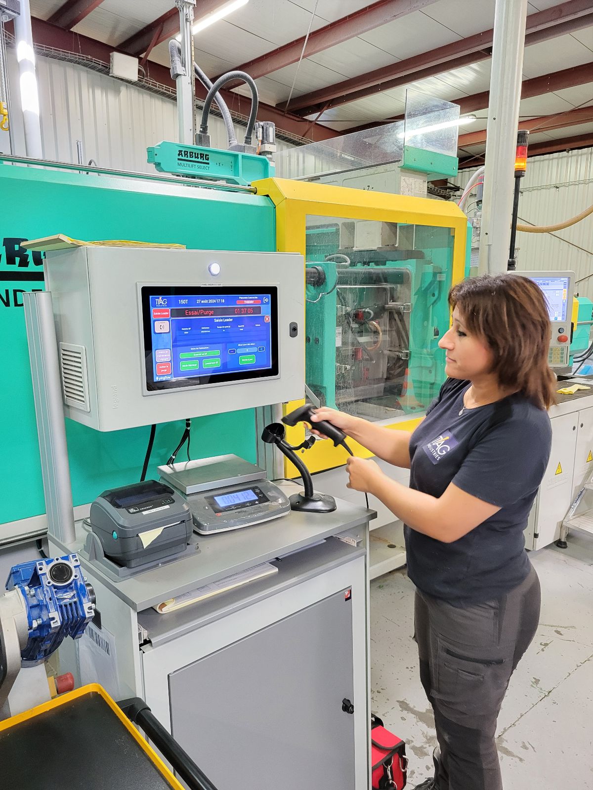 Comment TIAG Industries accélère vers le 4.0 3 Femme avec un scanneur dans la main devant un pupitre connecté Tiag