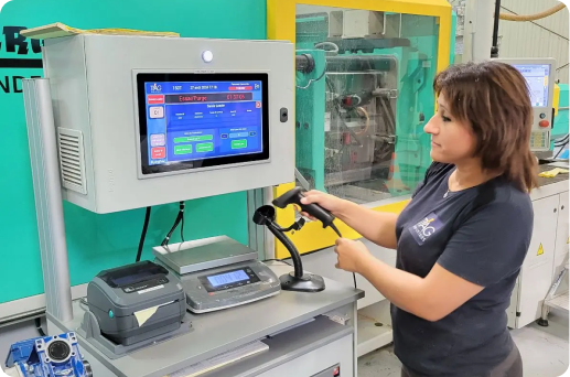 TIAG Femme avec une douchette pour scanner et demarrant un OF. On voit l'OF sur la tablette a cote d'elle.